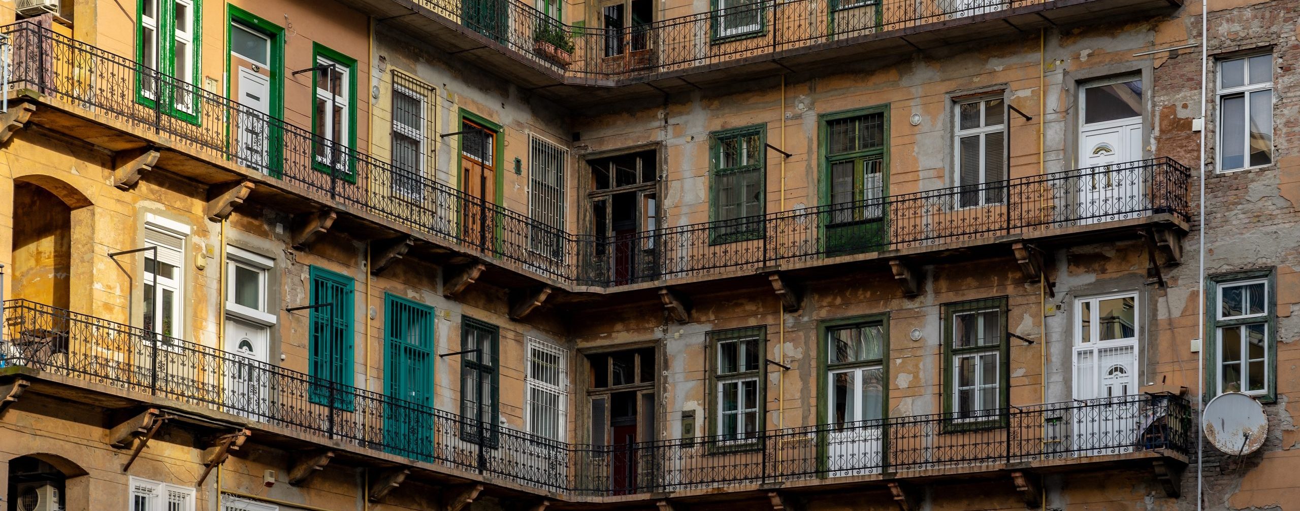 old,traditional,yellow,residential,building,in,budapest,with,gang,and